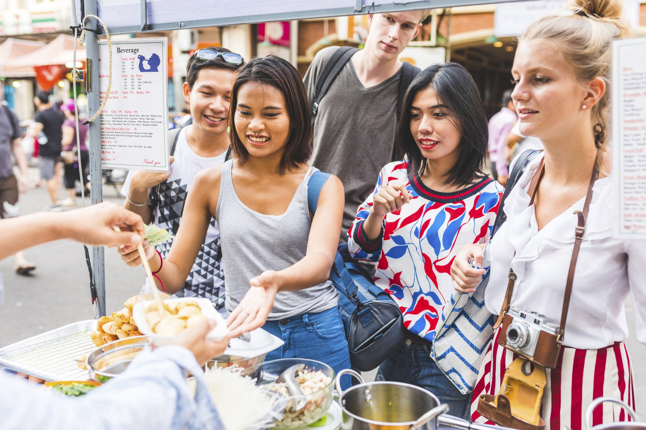Thailand, Bangkok, Khao San Road, group of friends testing local food on street market
